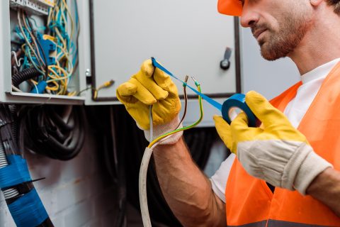 cropped view of electrician using insulating tape 2023 11 27 04 54 03 utc